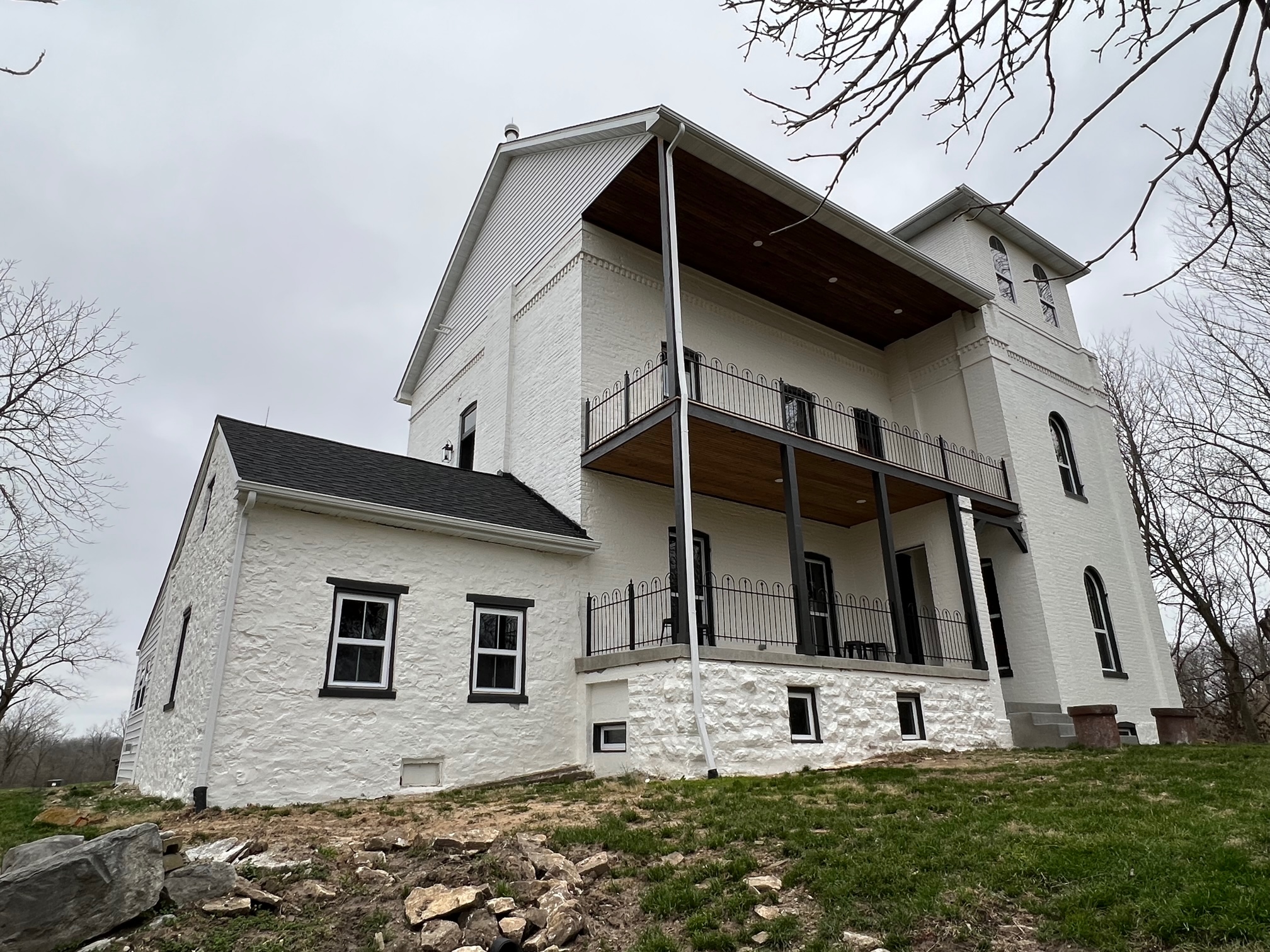 Restored historic home exterior with wraparound porches and white masonry